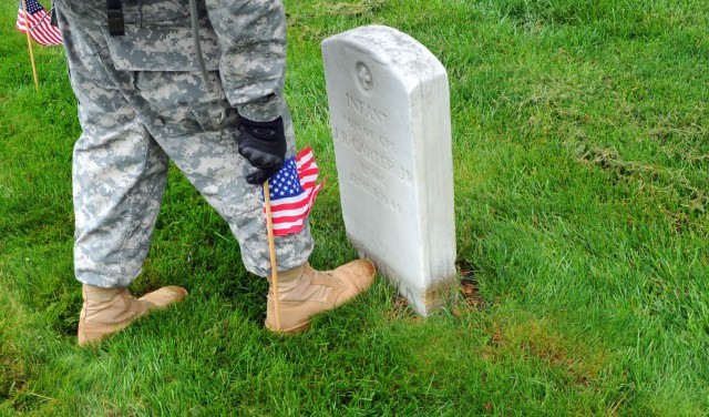 Soldiers participate during Flags In at Arlington Cemetery