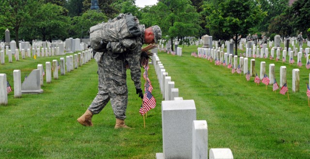 Soldiers participate during Flags In at Arlington Cemetery