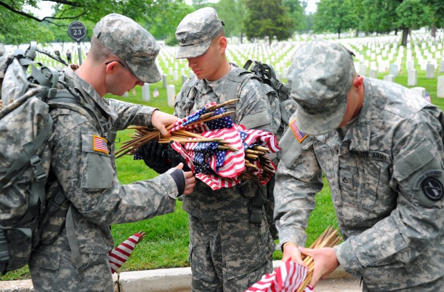 Soldiers participate during Flags In at Arlington Cemetery
