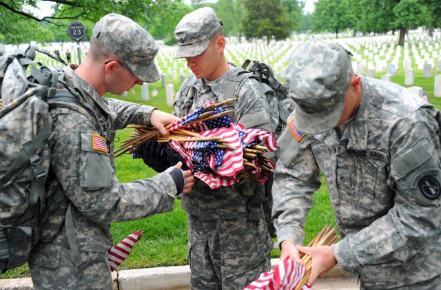 Soldiers participate during Flags In at Arlington Cemetery