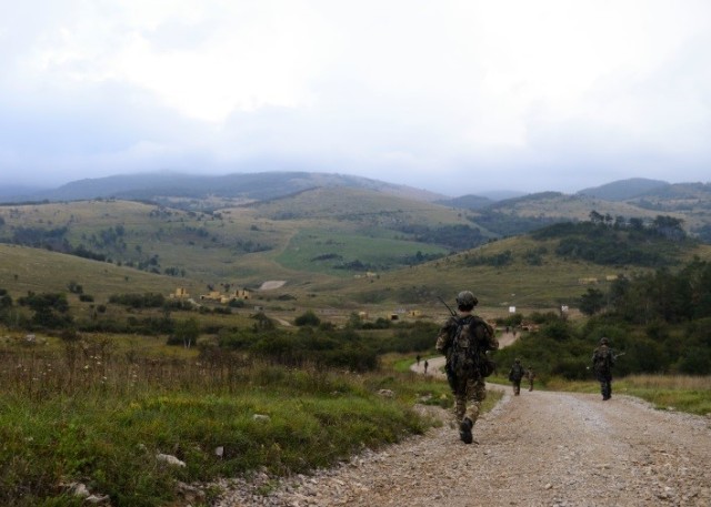 Albanian and Slovenian soldiers move towards an assembly point.