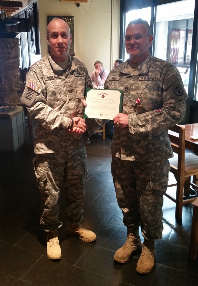 Sgt. 1st Class Charles Hill III (Right) receives Meritorious Service Medal from Director U.S. Army Wounded Warrior Program Colonel David Oeschger