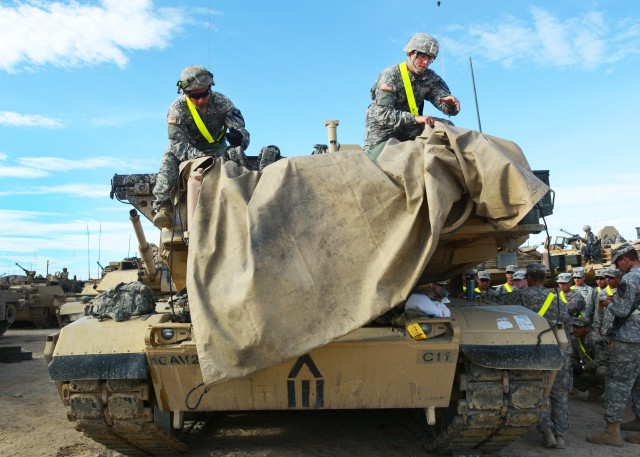 Private Jose Valadez and Cpl. Joshua Tipton un-cover rear of M1 Abrams tank