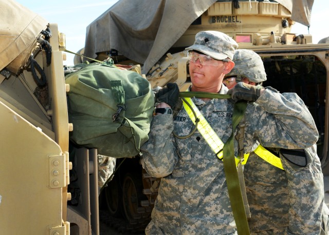 Spc. Joshua Lemaster and Pvt. Randall Sheriff strap bags