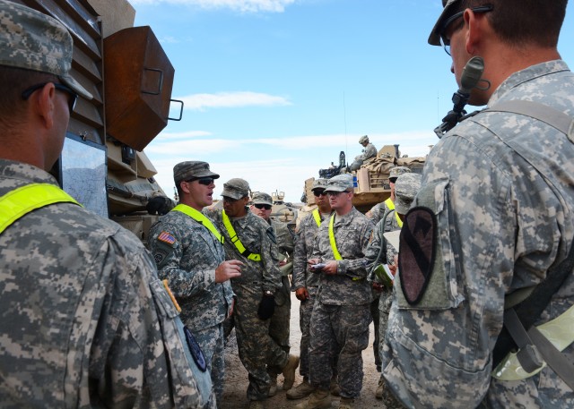 Capt. Daniel Davison speaks with Soldiers at side of M1 Abrams tank