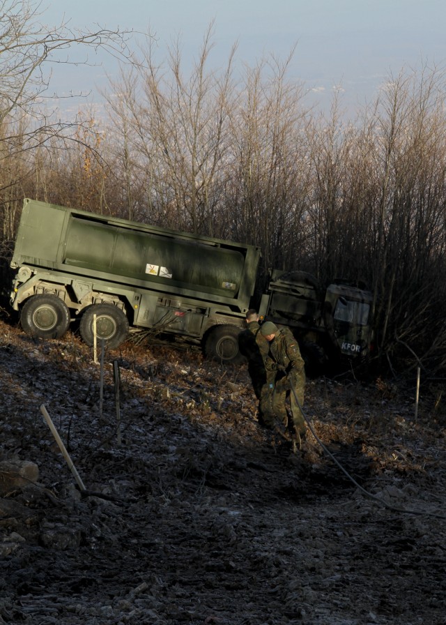 Multinational soldiers work together in vehicle recovery