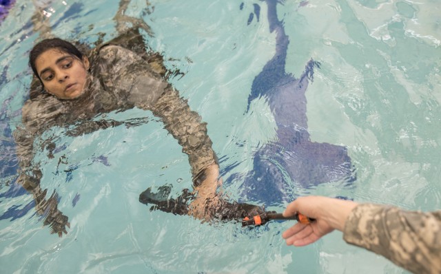 Female cadet hands off M16 from pool