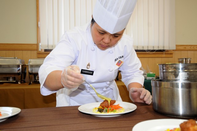 Sgt. 1st Class Elizabeth Yarbrough, E Company, 4-2 Attack Reconnaissance Battalion, puts the finishing touches on a plate for the first course of the Eighth Army Culinary Arts Team End Course Meal, at