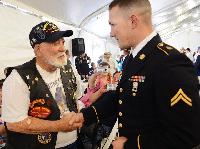 Cpl. Eli Marvin -- a Soldier with Headquarters and Headquarters Troop, 1st Squadron, 11th Armored Cavalry Regiment -- shakes hands with James Pinnix, a Vietnam War Veteran