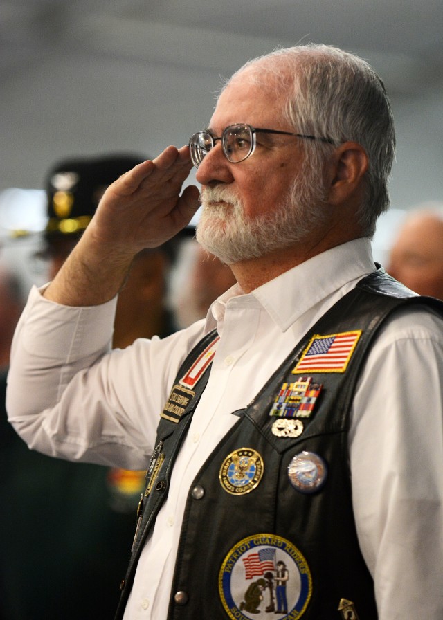 Doug Whetstone, an Air Force Veteran who served in Vietnam from 1969 to 1970, salutes during the national anthem