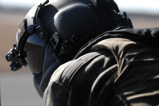 A crew chief looks out of a Black Hawk helicopter