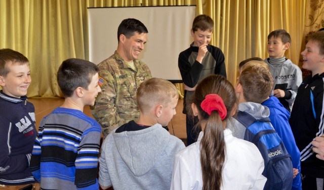 A U.S. Army civil affairs Soldier talks and laughs with Ukrainian school children following a health awareness class