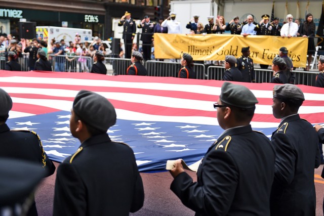 JROTC cadets march the American flag past the reviewing stand