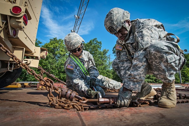 Soldiers secure a palletized load system to a railcar
