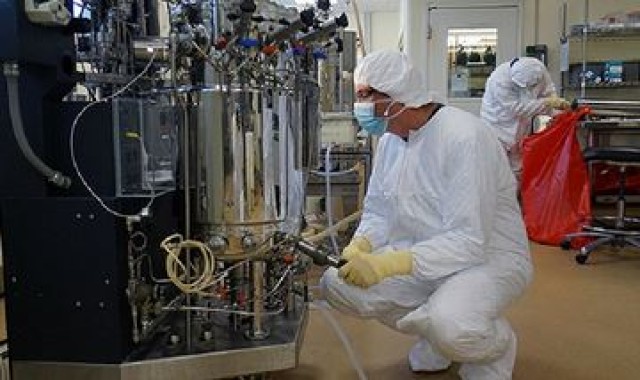 Researchers take a sample from the lab's fermenter