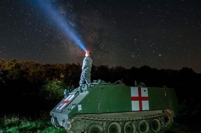 Staff Sgt. Brad Foster, a combat medic, looks up at the night sky