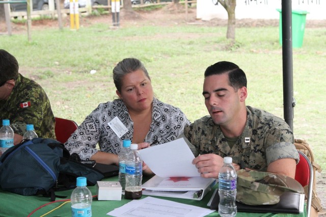 Rene Van Slate, U.S. Agency for International Development's Office of U.S. Foreign Disaster Assistance (left), and Capt. Grant Crochet, 3 MEB, MARFORPAC, discuss disaster response solutions between U.