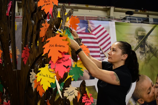Sgt. 1st Class Natasha Suarez places leaf on the SOS memorial tree