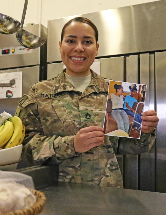 U.S. Army Staff Sgt. Maylin Matute holds up a photo of her younger brother, Carlos, Jan. 12, Baghdad Iraq.