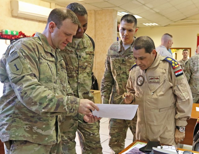 U.S. Air Force Maj. Aaron Tillman, CJOC-B Air Advisor, discusses logistics with Iraqi Brig. Gen. Mustafa, Iraq Air Director, in the Combined Joint Operations Center -- Baghdad, Jan. 7.