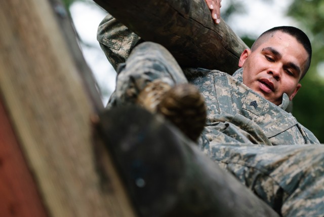 Sgt. Roberto J. Cruz navigates the reverse climb portion of the confidence course at the 301st Maneuver Enhancement Brigade Best Warrior competition