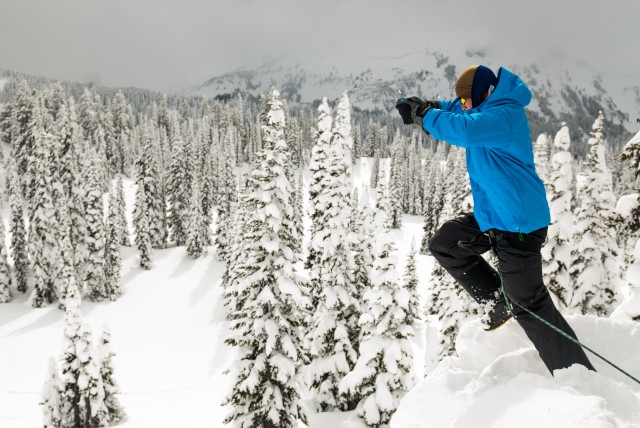 Joseph Byrnes leaps off of a snow bank to simulate falling into a crevasse, at the JBLM Alpine Club basic alpine course, Mount Rainier National Park