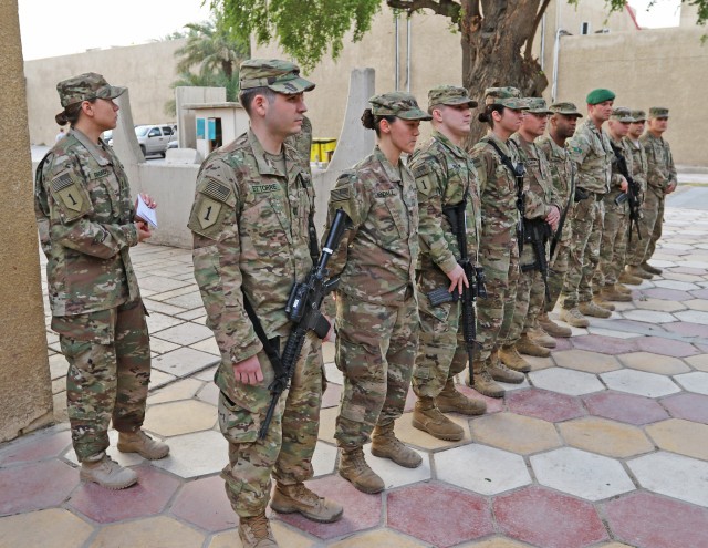 Master Sgt. Stephanie Rhoads lines up servicemembers for a coining ceremony