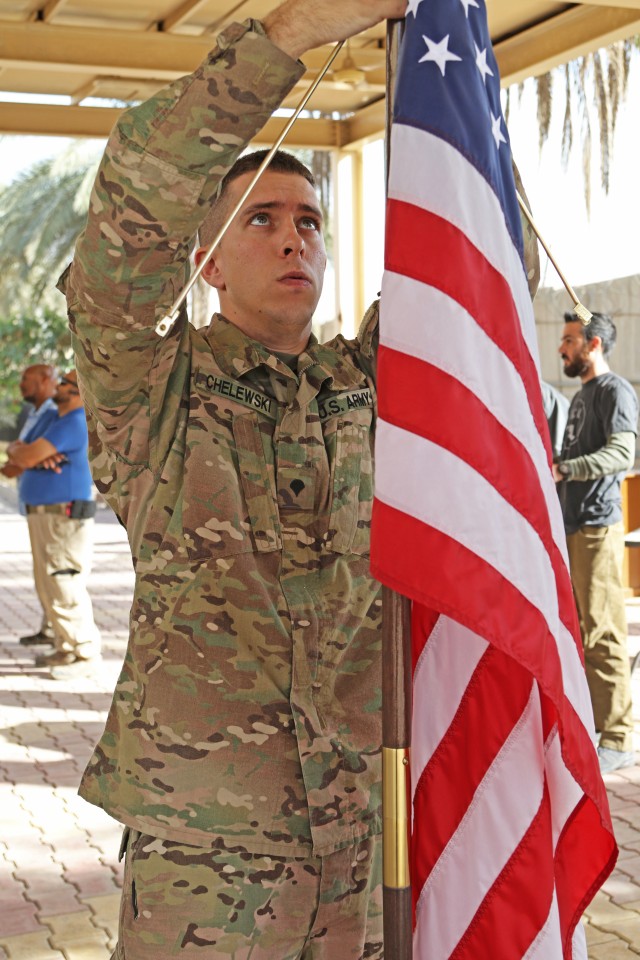 Joint Visitors Bureau Spc. Michael Chelewski hangs a flag in preperation for a promotion ceremony