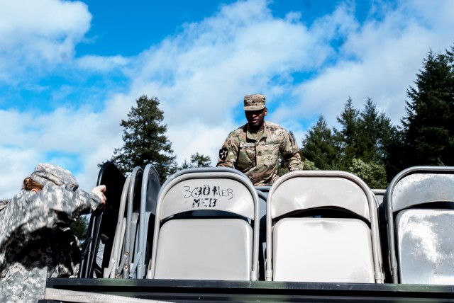 Soldiers from the 301st Maneuver Enhancement Brigade begin to unload cargo from a light medium tactical vehicle