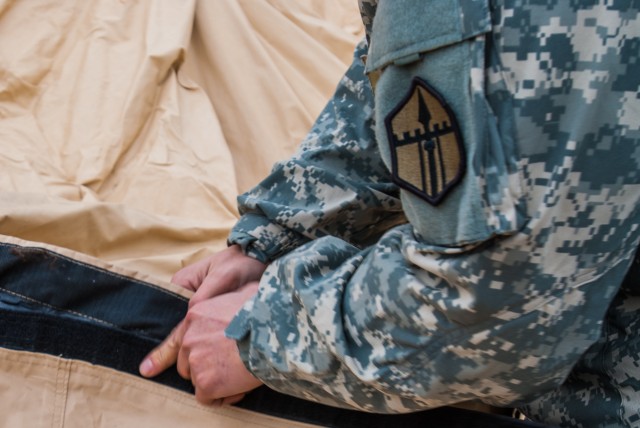 A soldier from Headquarters and Headquarters company, 301st Maneuver Enhancement Brigade, assembles a deployable rapid assembly shelter (DRASH) at Joint Base Lewis-McChord, Washington