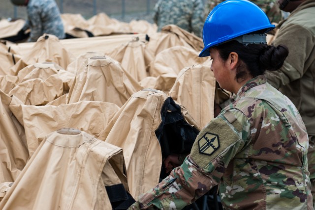A soldier disassembles a deployable rapid assembly shelter (DRASH) at Joint Base Lewis-McChord, Washington