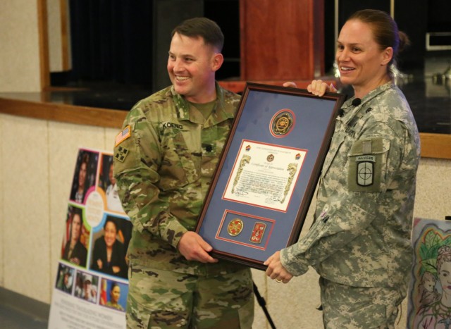 Lt. Col. Erik E. Koenig, 36th Signal Battalion commander, presents U.S. Army Reserve Maj. Lisa Jaster with a framed certificate of appreciation. The 36th Signal Battalion, in coordination with the Are
