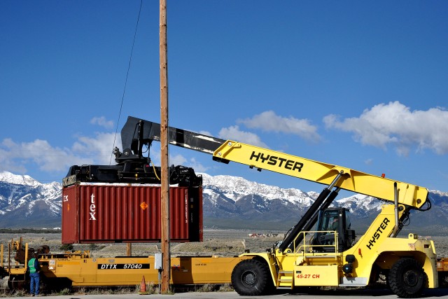 TEAD employee maneuvers full container onto railcar