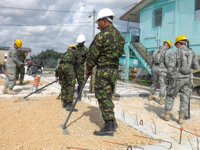 Soldiers assigned to the 301st Maneuver Enhancement Brigade, along wiht soldiers with the Belize Defense Force to spread and compact gravel