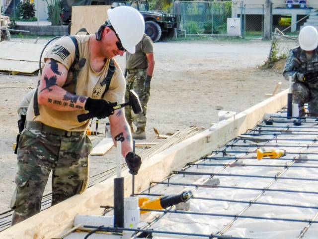 Sgt. Timothy Augusti drives a piece of rebar in a pre-drilled hole