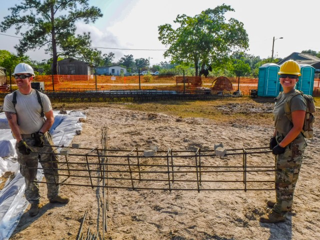 Soldiers with the 301st maneuver Enhancement Brigade carry a rebar form cage