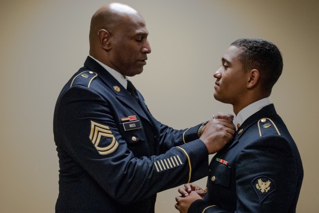 Spc. Donovan Boatwright ensures his uniform has a proper fit