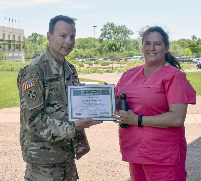 LaShon Turner, registered nurse at Irwin Army Community Hospital, received of the first DAISY Award May 8 in the hospital's healing garden.