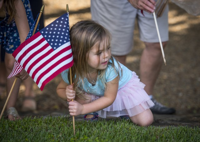 Little girl places American flag