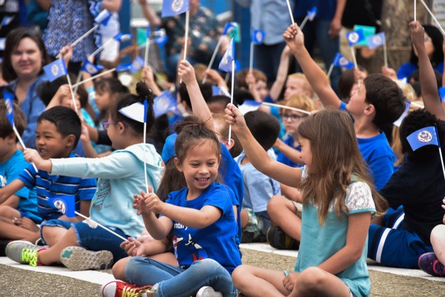 Students of Seoul American Elementary School wave their blue ribbon flags to show their pride in winning the award