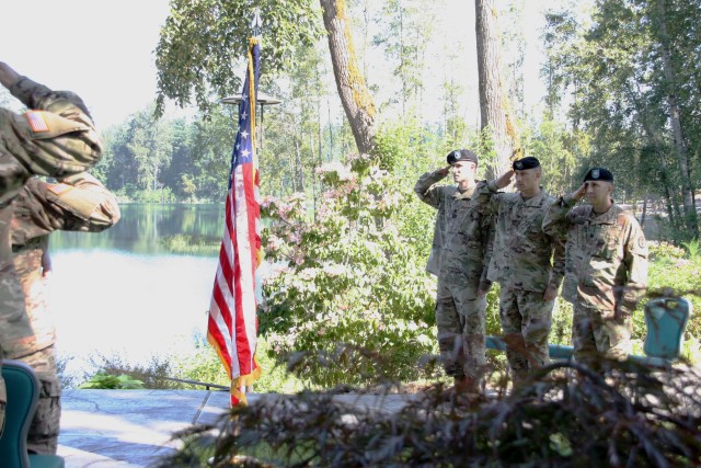 Three commanders salute flag