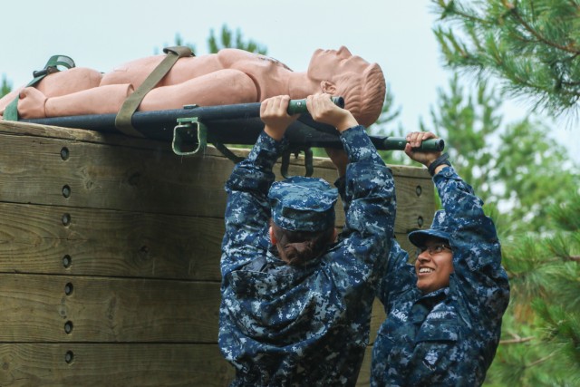 Navy Reserve Hospital Corpsman maneuver simulated wounded over obstacles