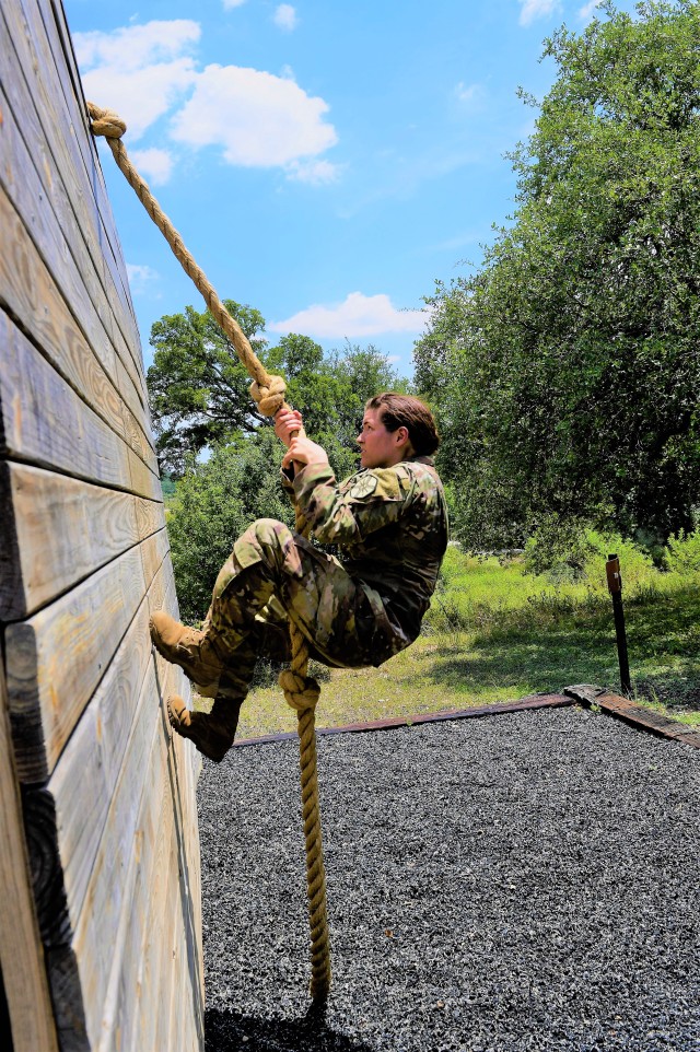 Spc. Lillian Lewis climbs wall in Best Warrior Competition