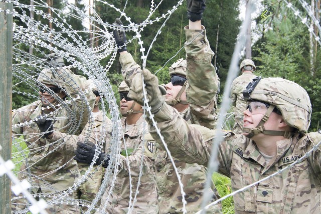 Soldiers wrap the wire along fence