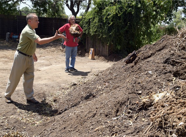 Army environmentalist Bob Blaesing tosses coffee grounds into compost pile