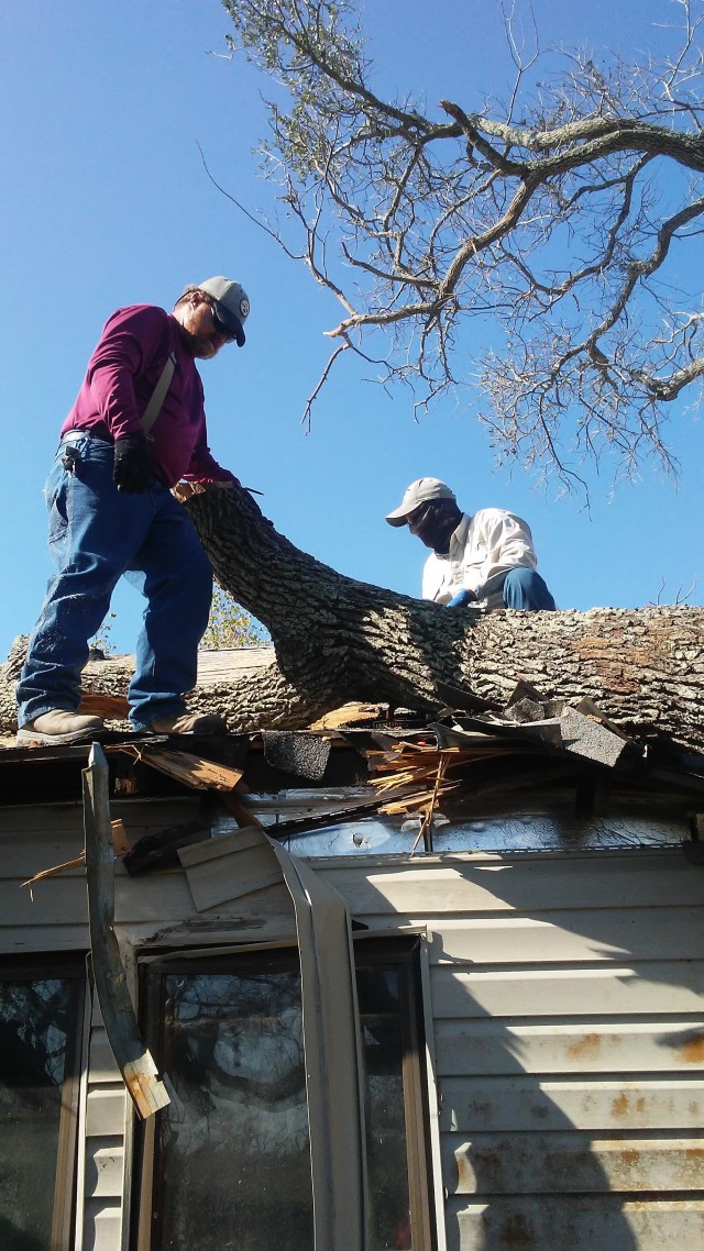 Volunteers remove tree from coworkers house after Hurricane Harvey