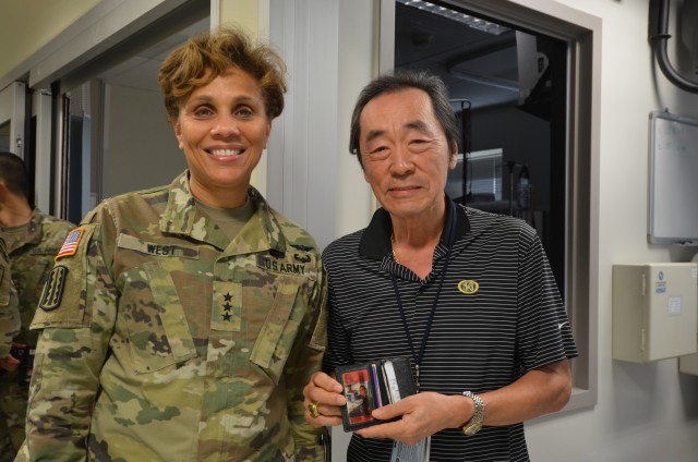 Mr. Oh shows Lt. Gen. West a picture he has been carrying in his wallet