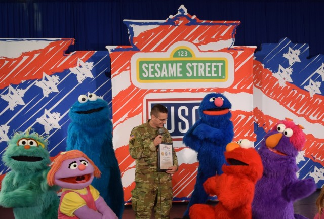 Maj. Trainor presents certificate of appreciation to Sesame Street characters