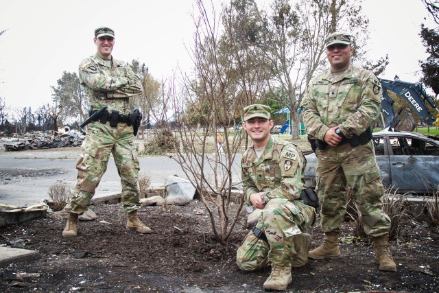 Amid ruins left by wildfire, California Army National Guard Soldiers nurture a little tree of hope