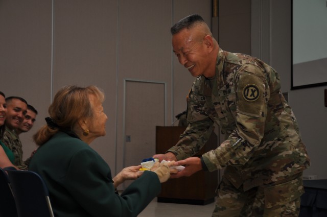 Brig. Gen. Curda, Commanding General of the 9th Mission Support Command, presents the first piece of cake to P. Pasha Baker, Army Reserve Ambassador to Hawaii.